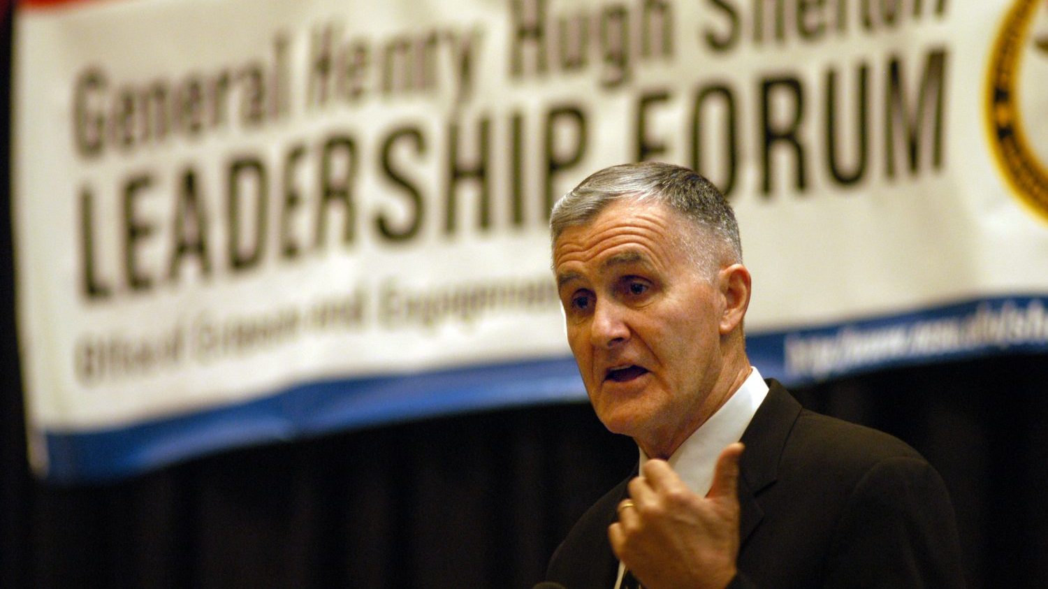 General Shelton speaking in front of a Leadership Forum banner.