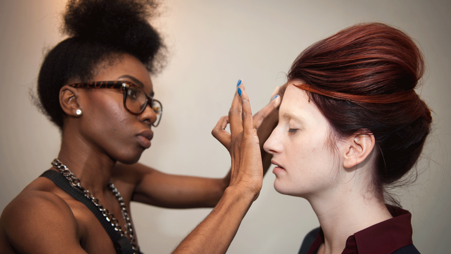 a makeup artist applies a model's makeup