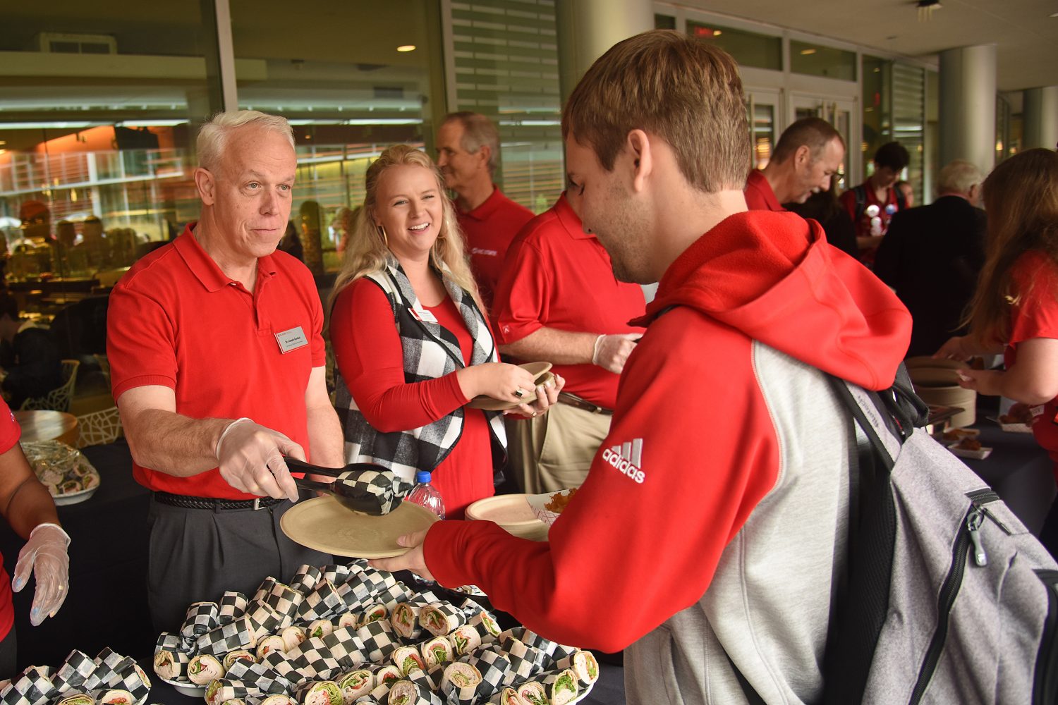 Volunteers serve food during Red and White Week in 2018