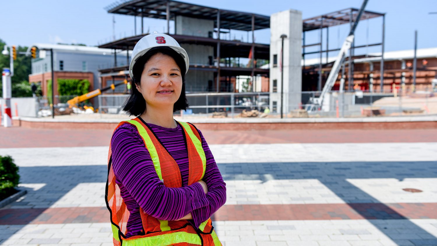 Dr. Min Liu stands in front of Wellness and Rec Center construction