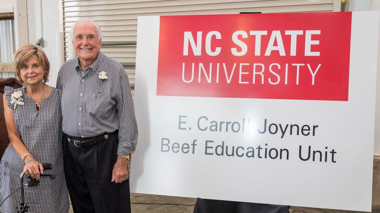 Caroll Joyner and his wife in front of Joyner Beef Education Unit sign