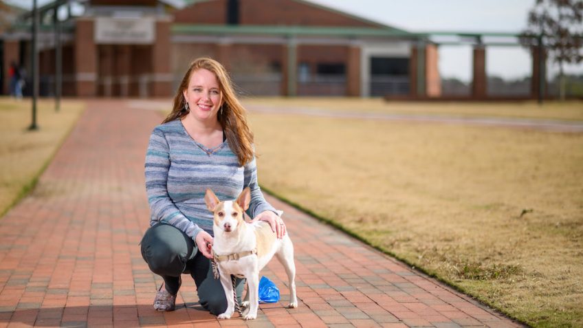 Samantha Zurlinden poses outside of the CVM Hospital with her rat terrier mix