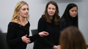Katie Lawson speaking in front of two other women at a roundtable discussion