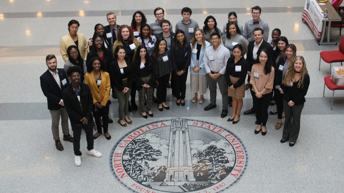 Study abroad scholars gather by the school seal