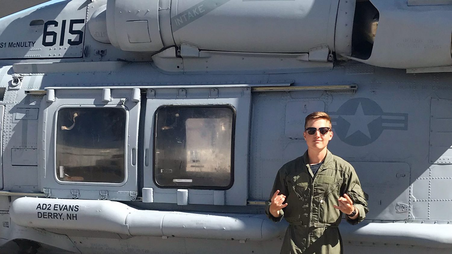 Garrett Welsh in front of a Navy helicopter