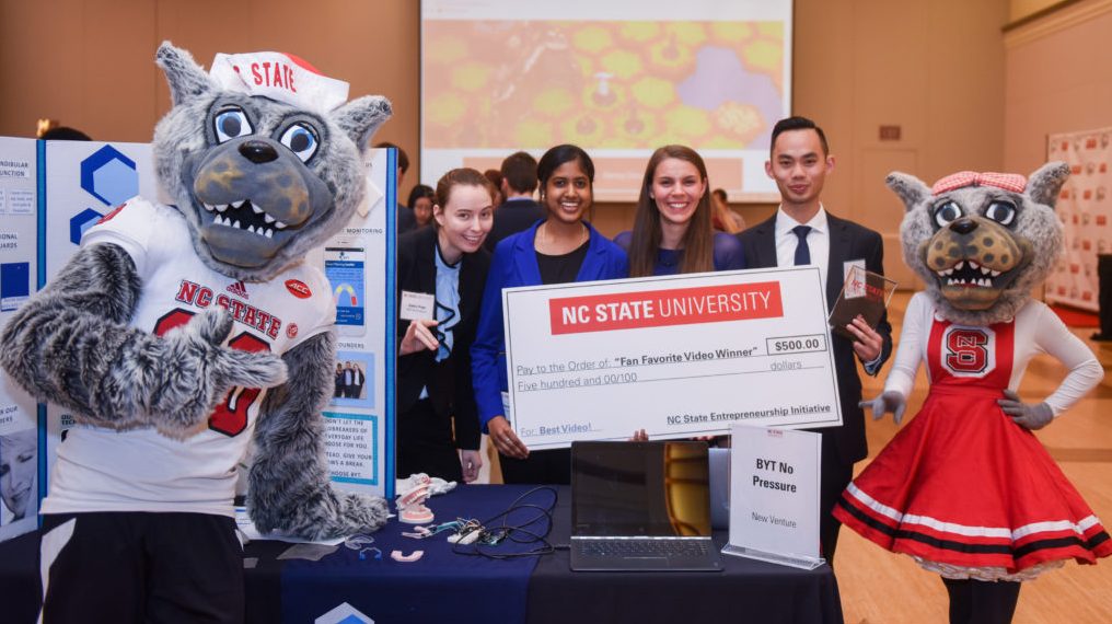 Lulu egames winners pose with the mascots and a giant check