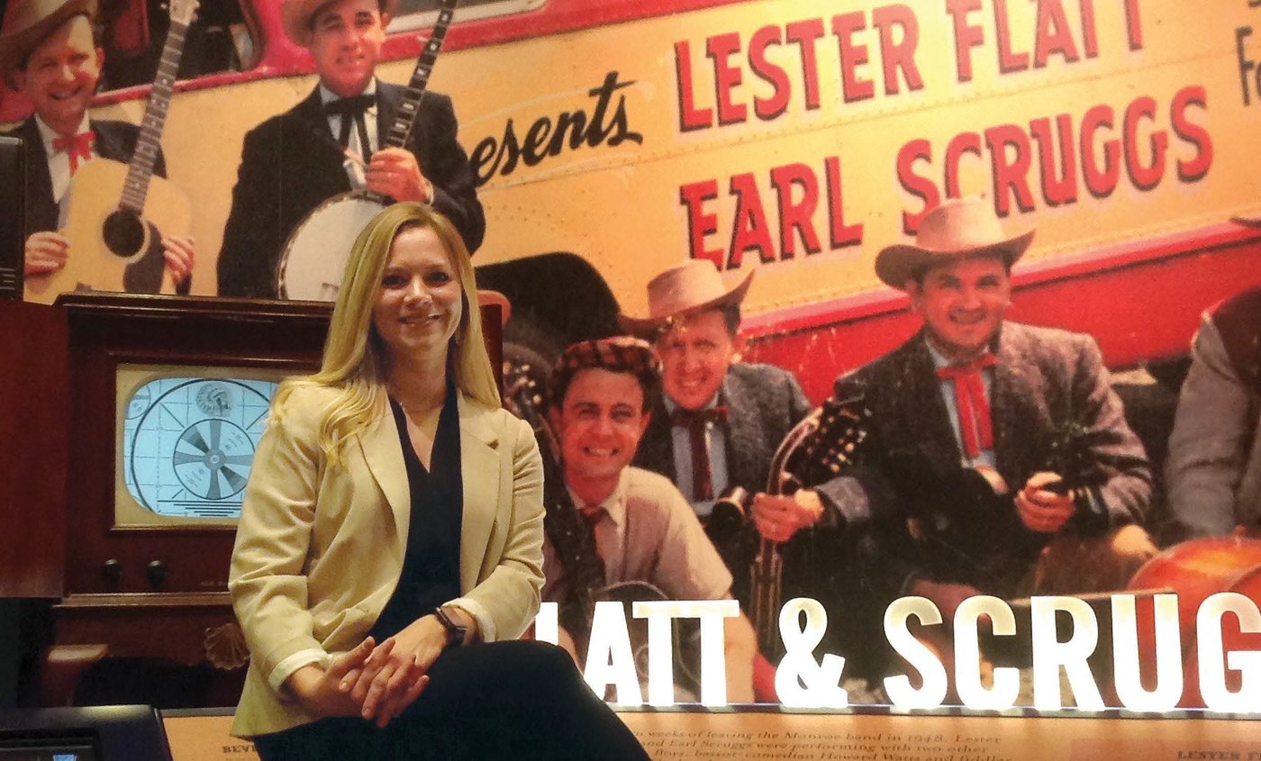 Mary Beth Martin in front of a Scruggs and Flatt poster
