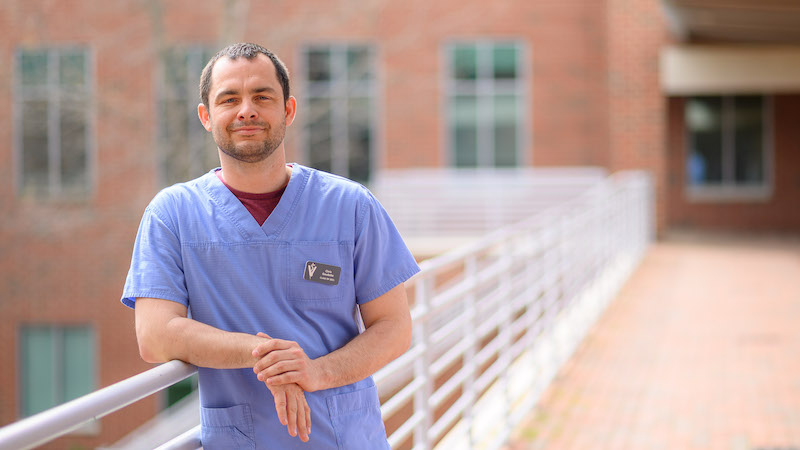 Chris Gaudette in scrubs in front of a CVM building