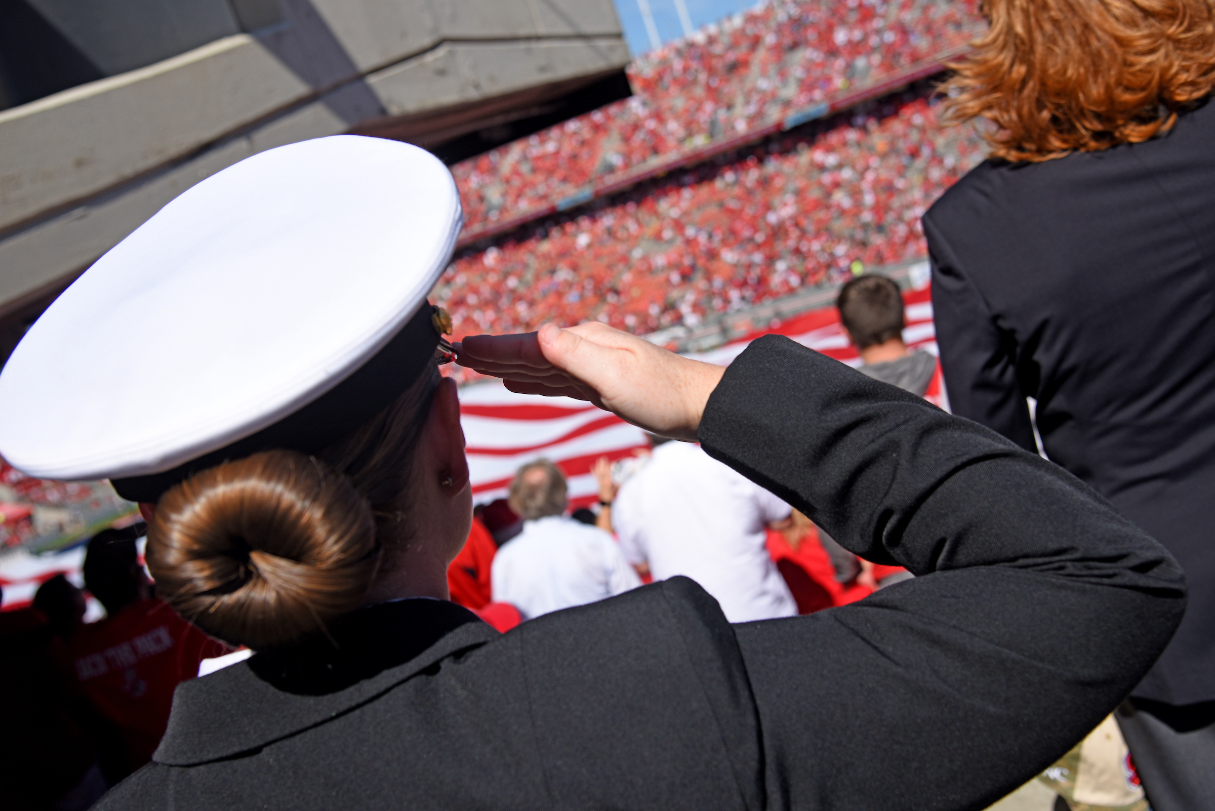 closeup of female student saluting a crowd at reynolds coliseum