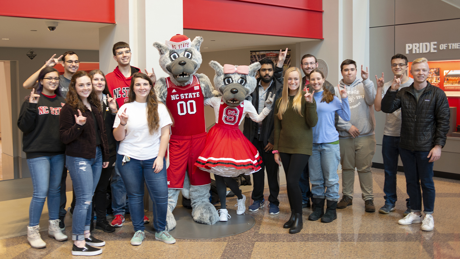 The Solomon Scholars pose with Mr. and Ms. Wuf inside Reynolds Coliseum