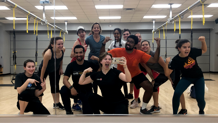 WellRec employees take a selfie while making silly poses in front of a mirror
