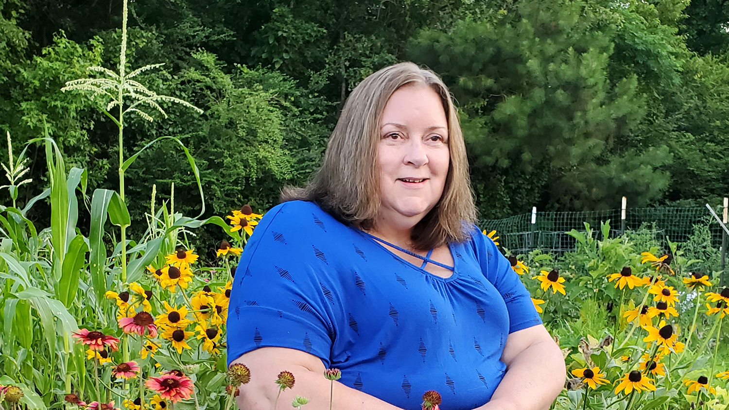Patty Fields sitting in a field of flowers