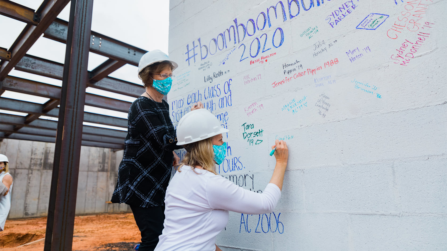 People writing on a building's interior wall before it's completed