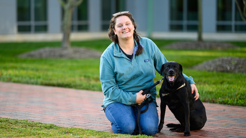 Annalee Thomasson with her Labrador mix, Kenya, outside at the NC State Veterinary Hospital.