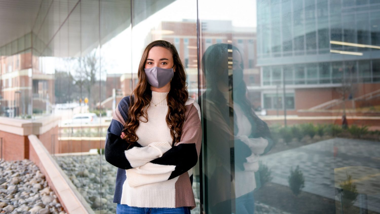 Victoria Moore poses in front of the WellRec Center while wearing a face covering