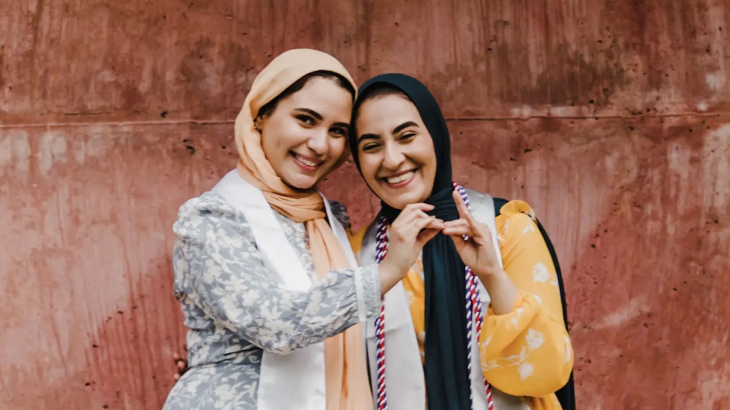 Iman, left, and Salam Ibrahim holding up the wolf ears symbol