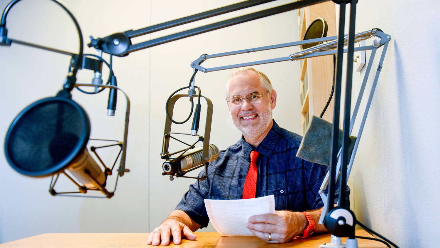 Dr. Mike Walden sitting at a microphone