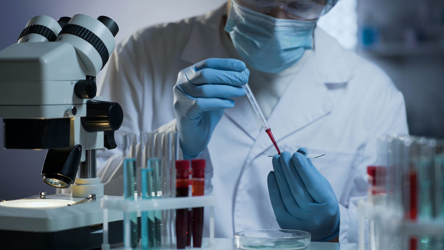A researcher working with test vials