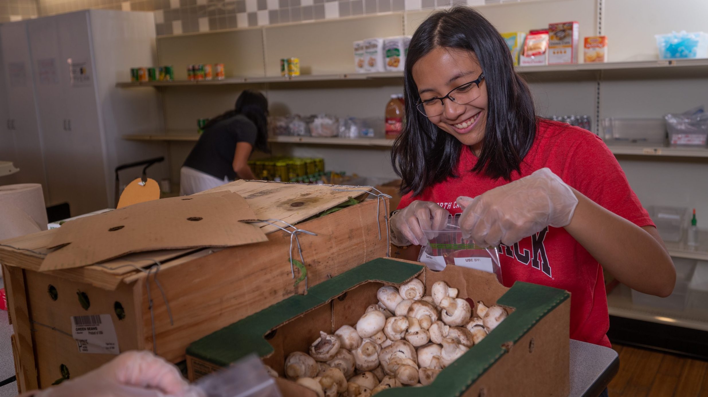 a student unboxing fresh produce at feed the pack