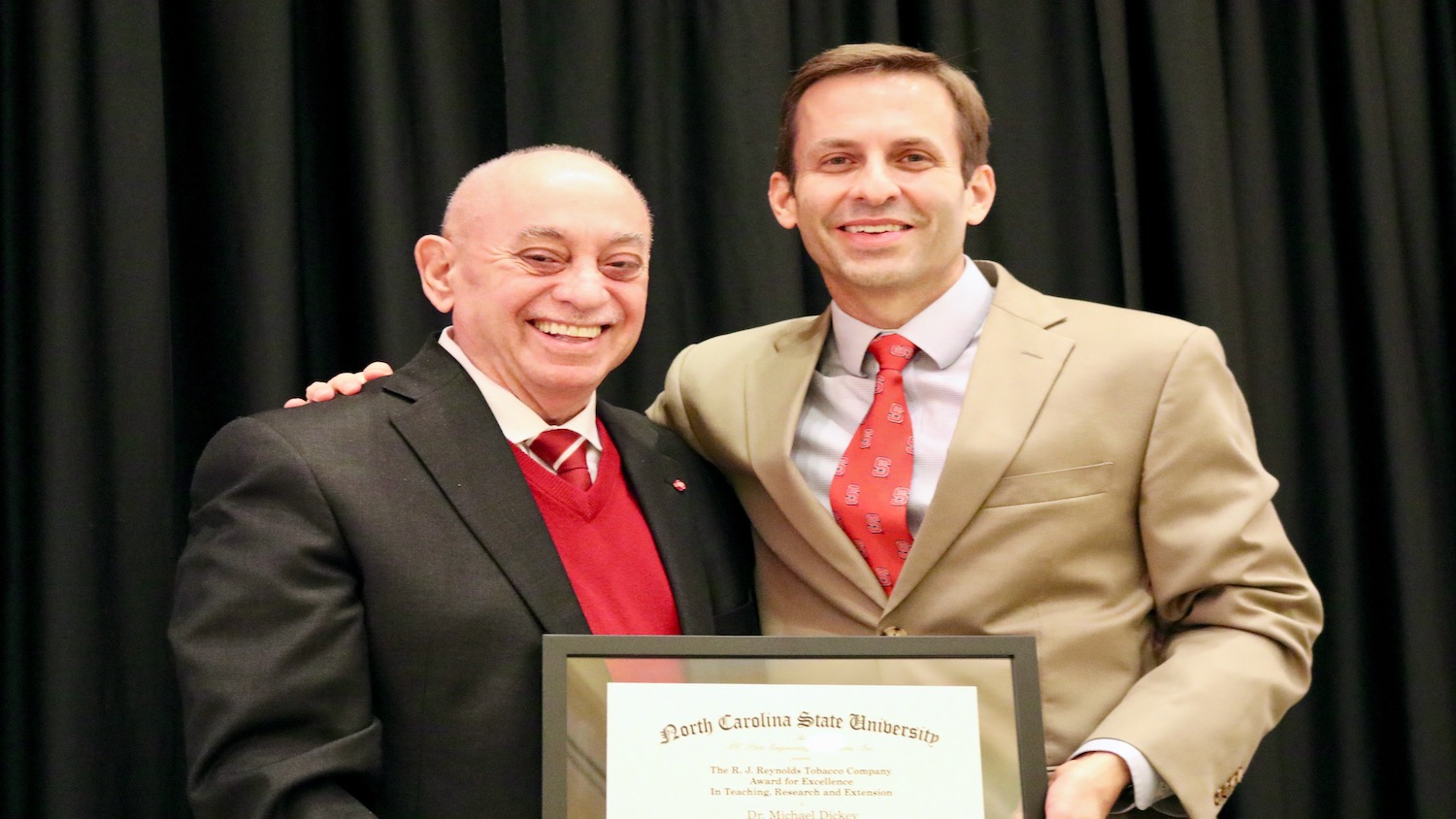 Dean Louis Martin-Vega (left) presents the RJ Reynolds Award certificate to Michael Dickey.