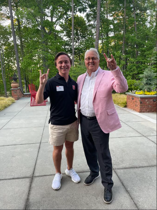 Dylan Inman and Chancellor Woodson posing outside together while giving wolfie hand symbols.
