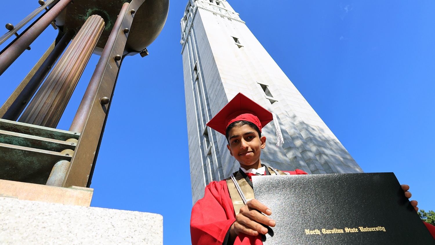 Madhusudan Madhavan in his cap and gown with his diploma at the Belltower