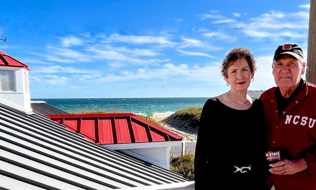 Pat and Jerry Collier at the beach by their red-roofed house