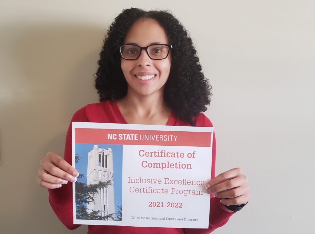 Carmen Russell holding her inclusive excellence certificate