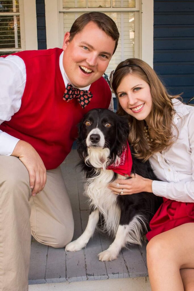 Alyssa, Kyle and their dog posing in their formal NC State gear
