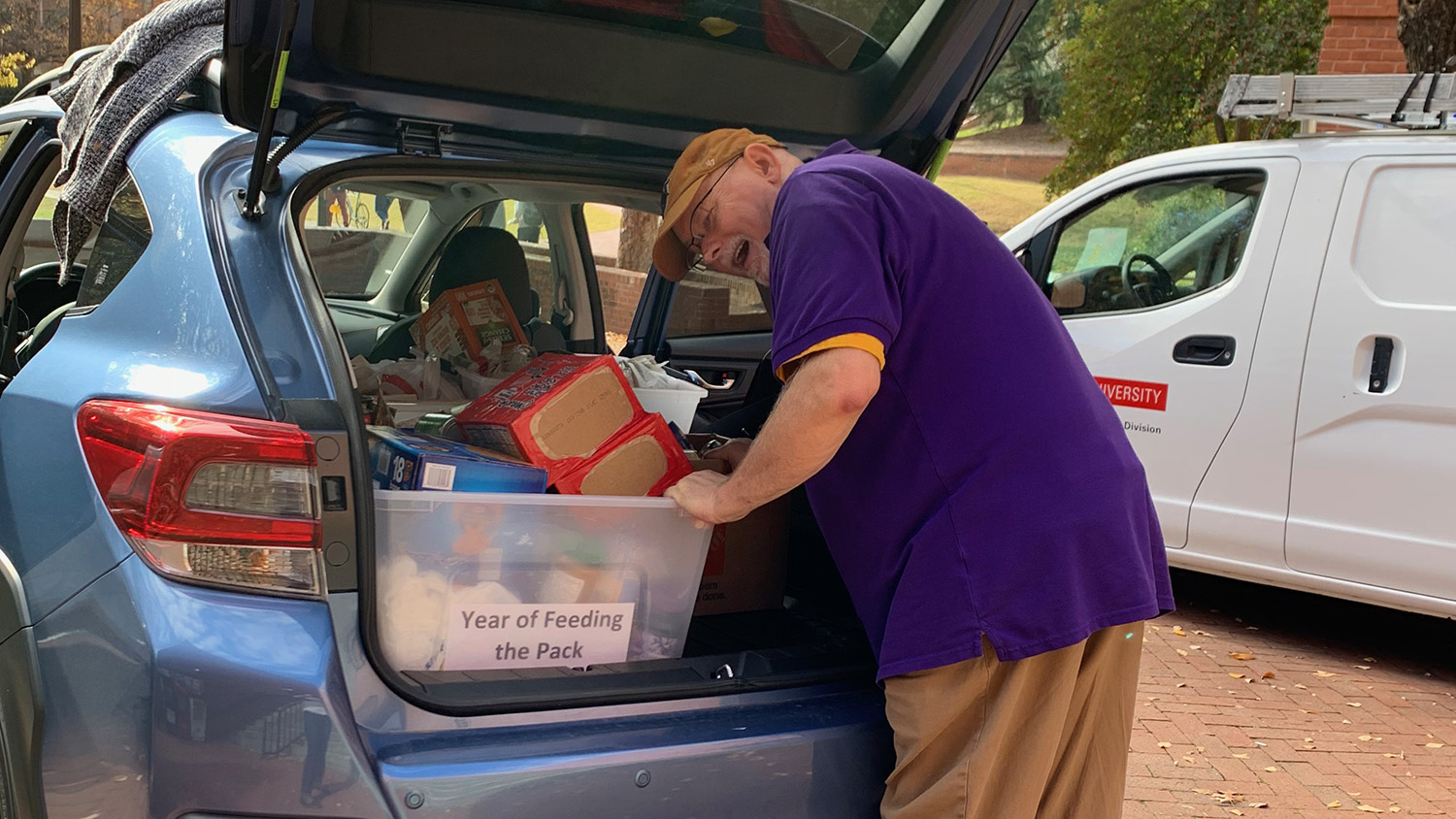 Person removing food donations from car trunk