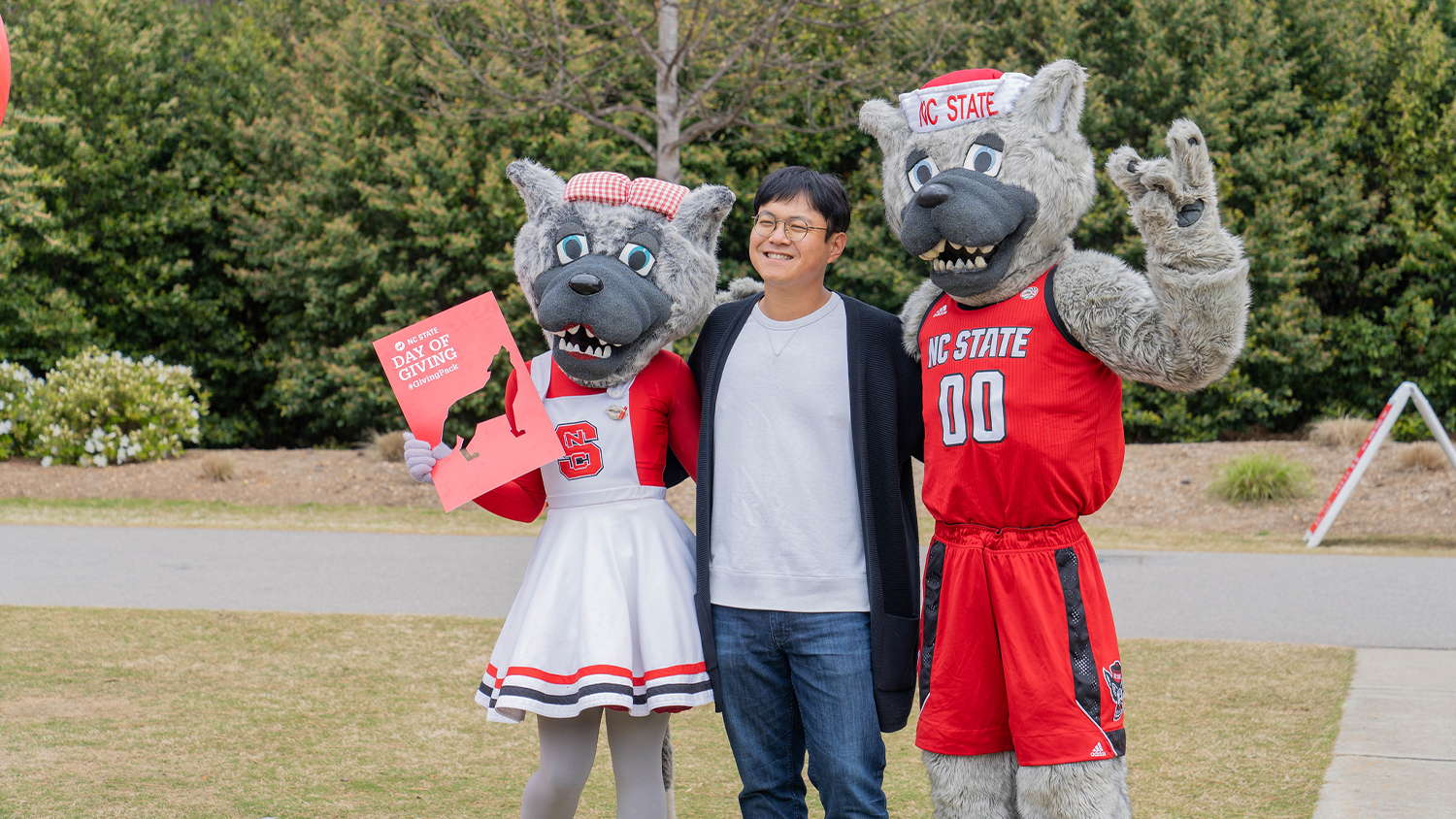 Student standing with Mr. and Ms. Wuf