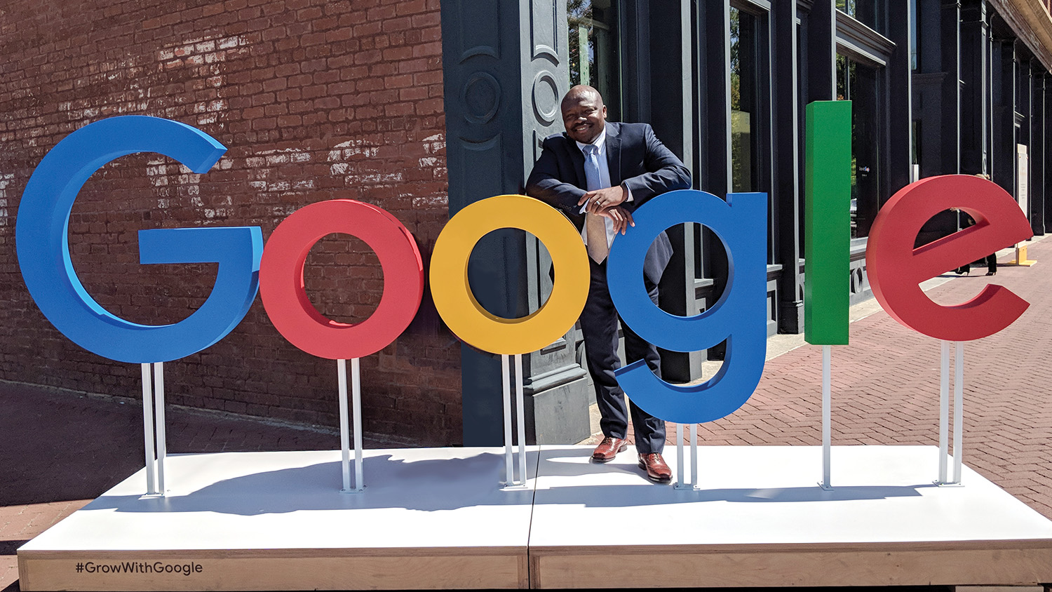 Wilson White standing behind a Google sign