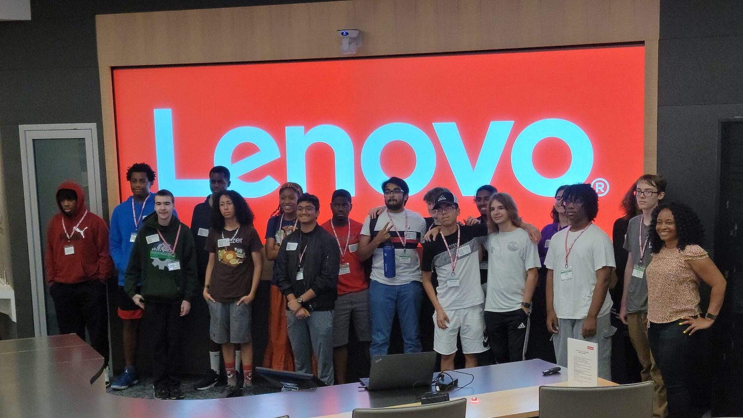 Students stand in front of a Lenovo logo