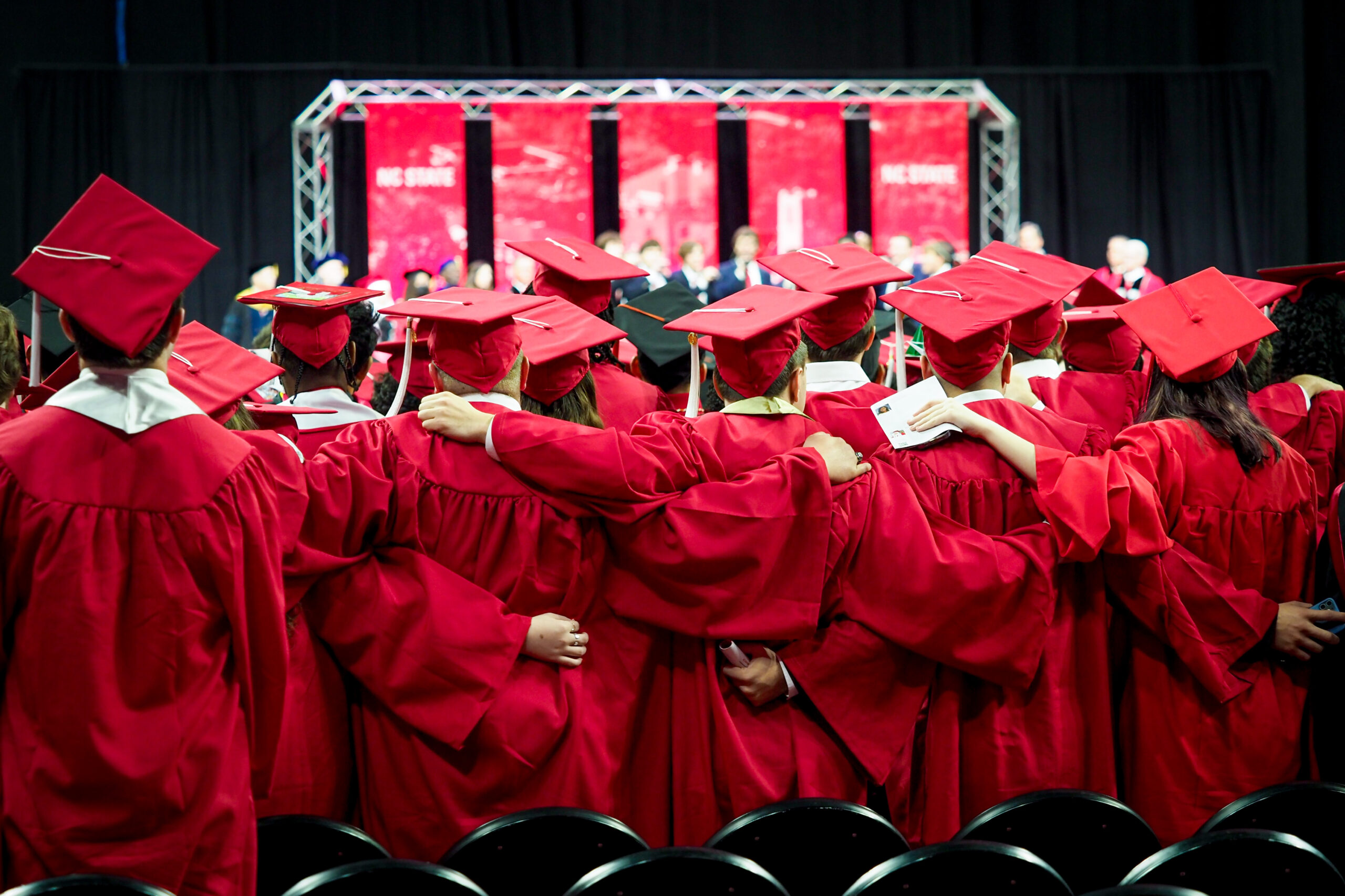 Students standing together in caps and gowns.