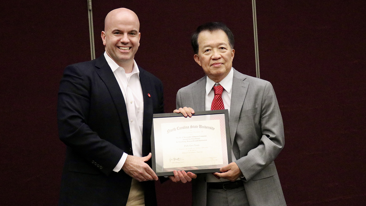 Dean Jim Pfaendtner, left, presents Fuh-Gwo Yuan the 2023 R.J. Reynolds Tobacco Company Award for Excellence in Teaching, Research and Extension.