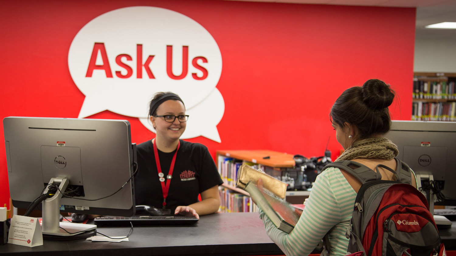 A student asks a student-worker for help at the Libraries' Ask Us desk