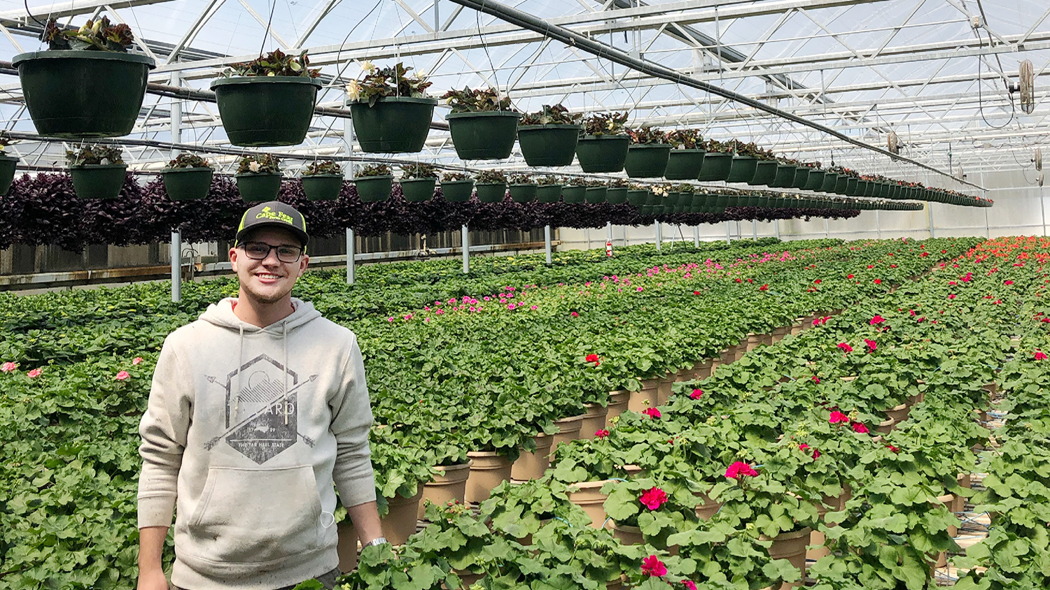 Malachi Curtis stands in the Cyn-Mar Inc greenhouses where he interned as the assistant grower.