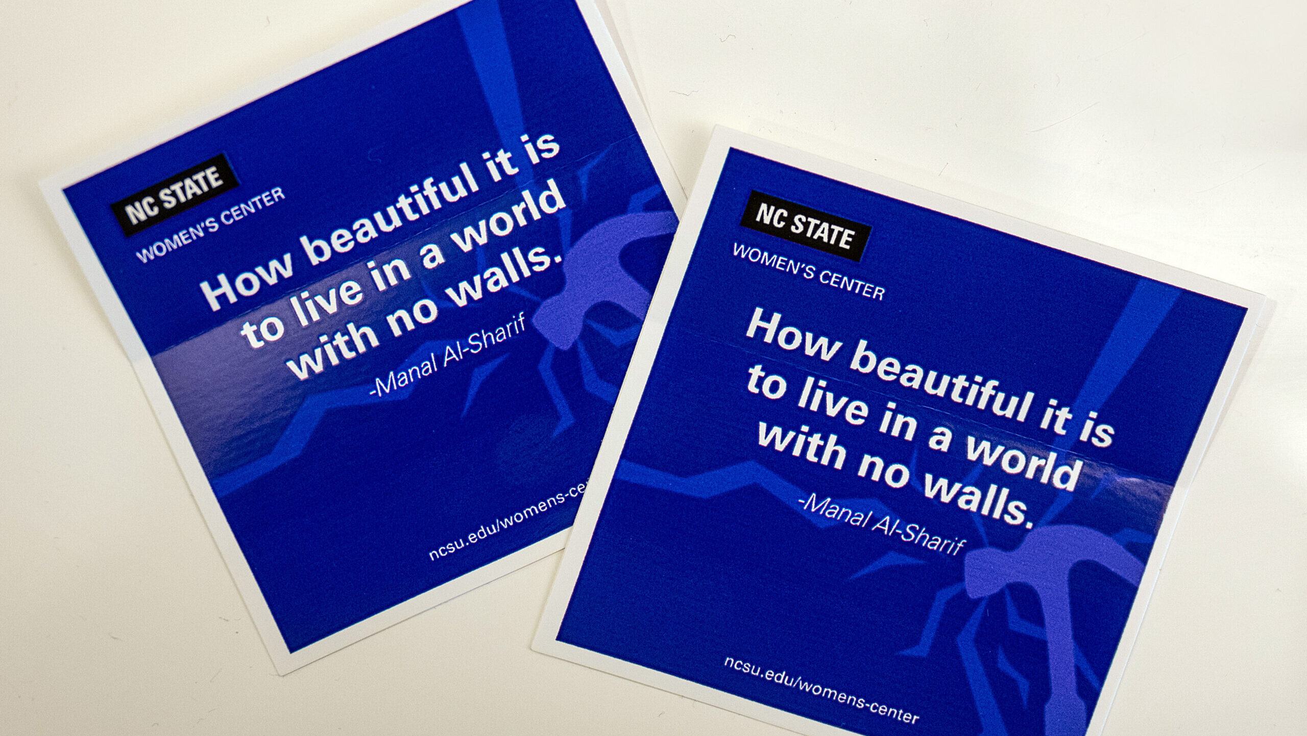 two cards that read "How beautiful it is to live in a world with no walls," a quote from Manal Al-Sharif