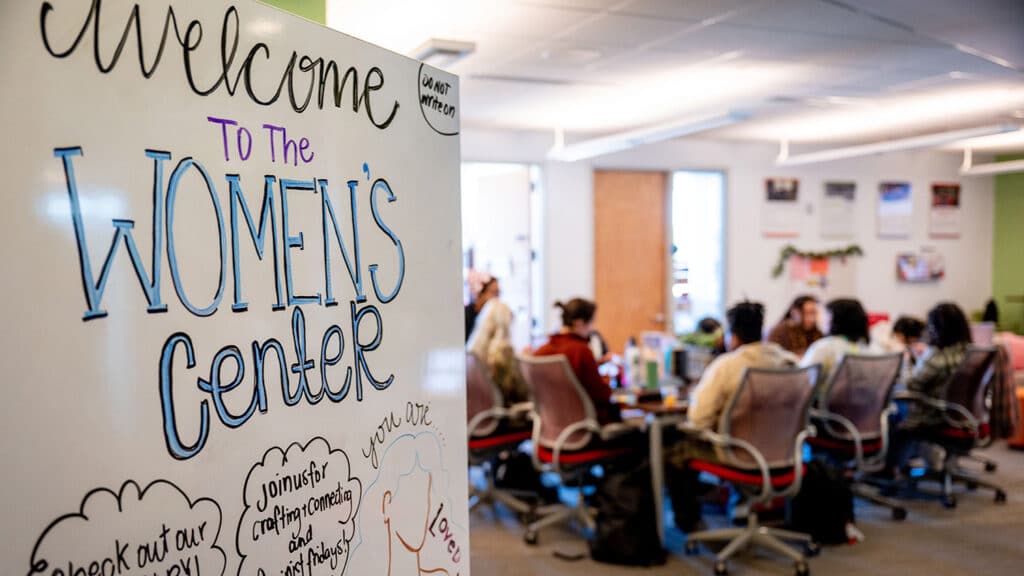 a sign welcoming entrants to the women's center in front of the crafting space