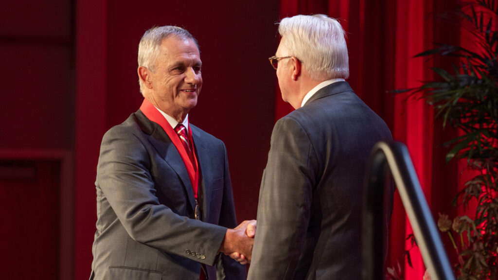 Jake Hook (left) shakes hands with Chancellor Randy Woodson.