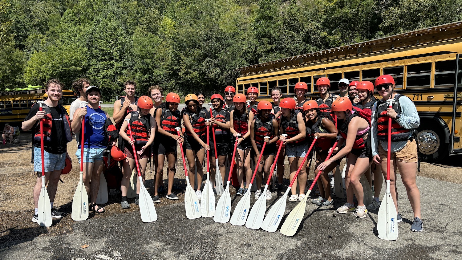 Members of the Park Scholarships’ class of 2025 pose for a photo in their life jackets and helmets with their paddles before going rafting.