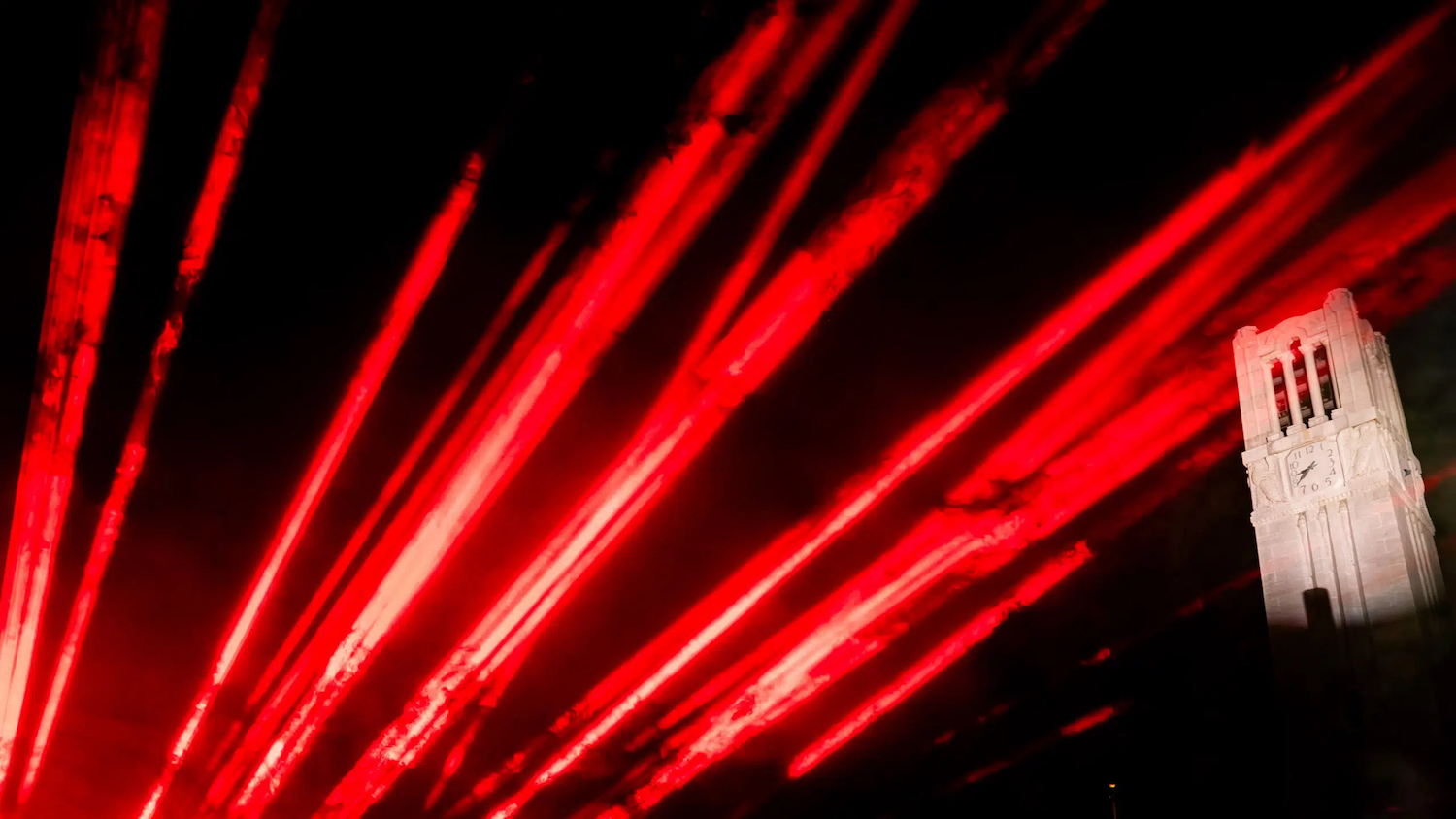 Red lights shining around the Memorial Belltower at Henry Square