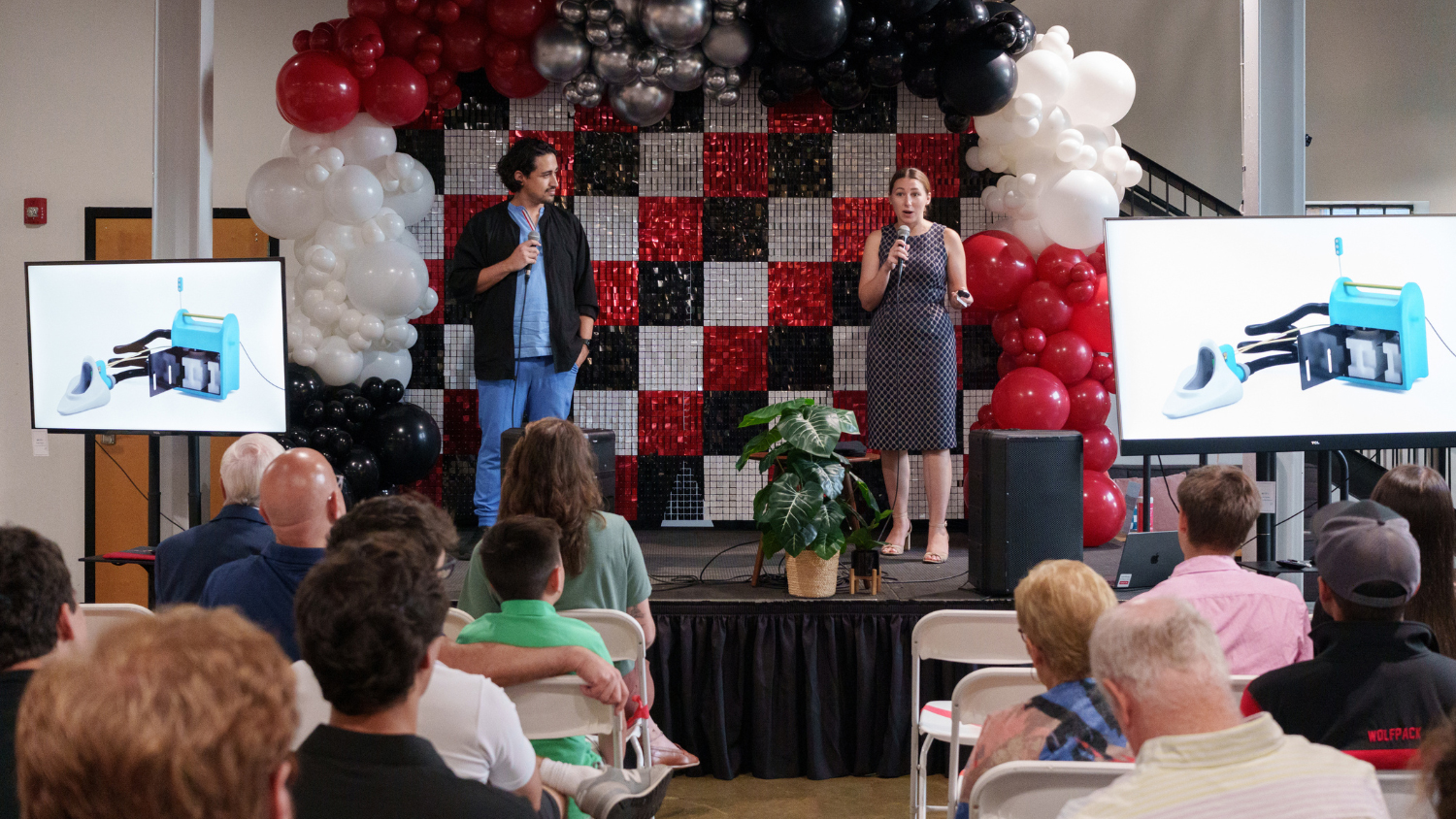 Startup founders on stage at Demo Day, giving their five-minute pitch to the audience of 175 innovators, investors and NC State students.