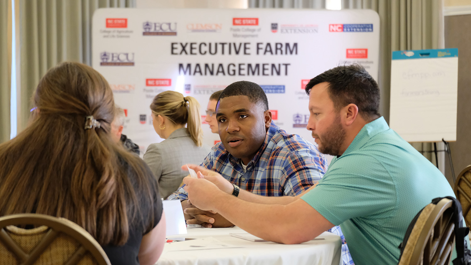 People talking at a table during an Executive Farm Management meeting