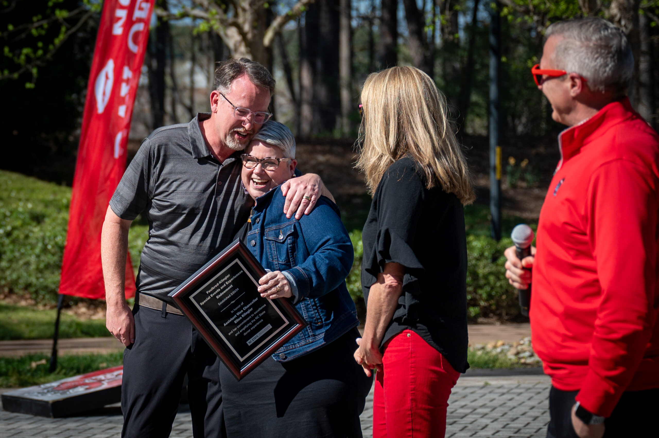 Allin Foulkrod and Ellen Klingler hug as Vice Chancellor for University Advancement Brian Sischo (right) announces the creation of the Foulkrod-Klingler Endowment. Barbara (second from right) and Allin Foulkrod created the endowment to support staff development opportunities for NC State’s special events team, of which Klingler is the leader.