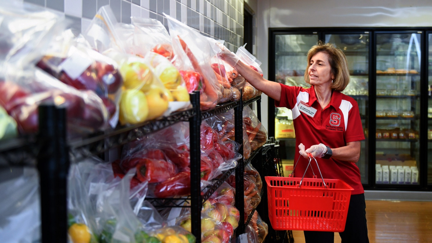 A Feed the Pack volunteer loads a basket in the food pantry.