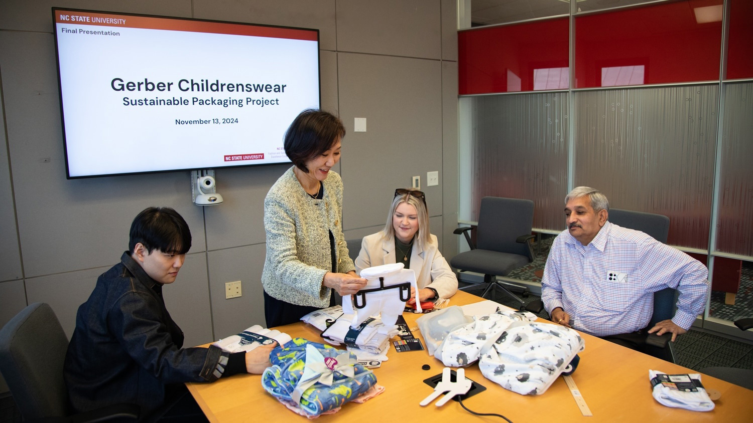 Ellie Jin (standing) examines Gerber childrenswear with her colleagues.