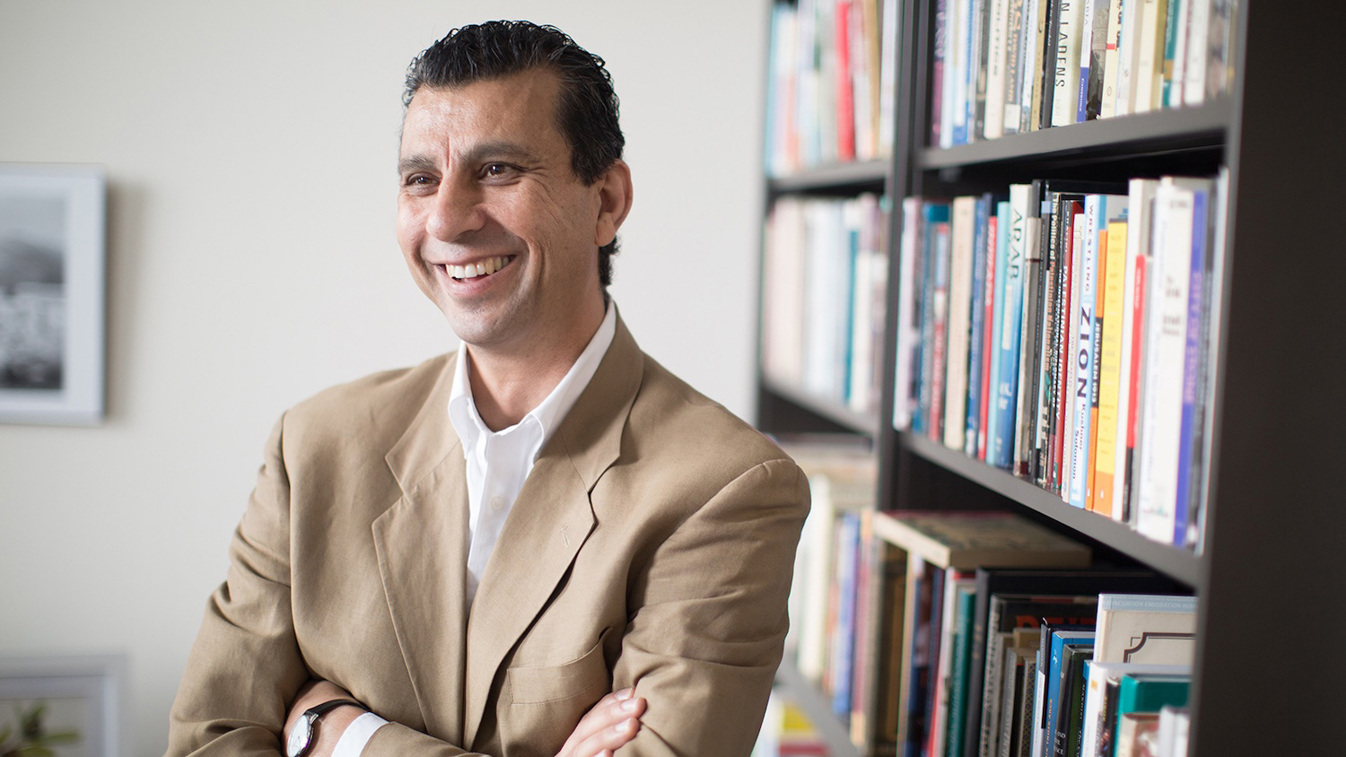 Akram Khater standing in front of a bookshelf