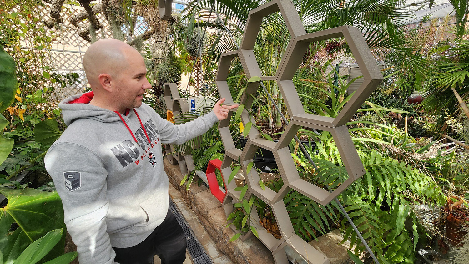 Twenty-year Navy veteran and AGI horticultural student Wes Fox describes the features of a vanilla orchid.