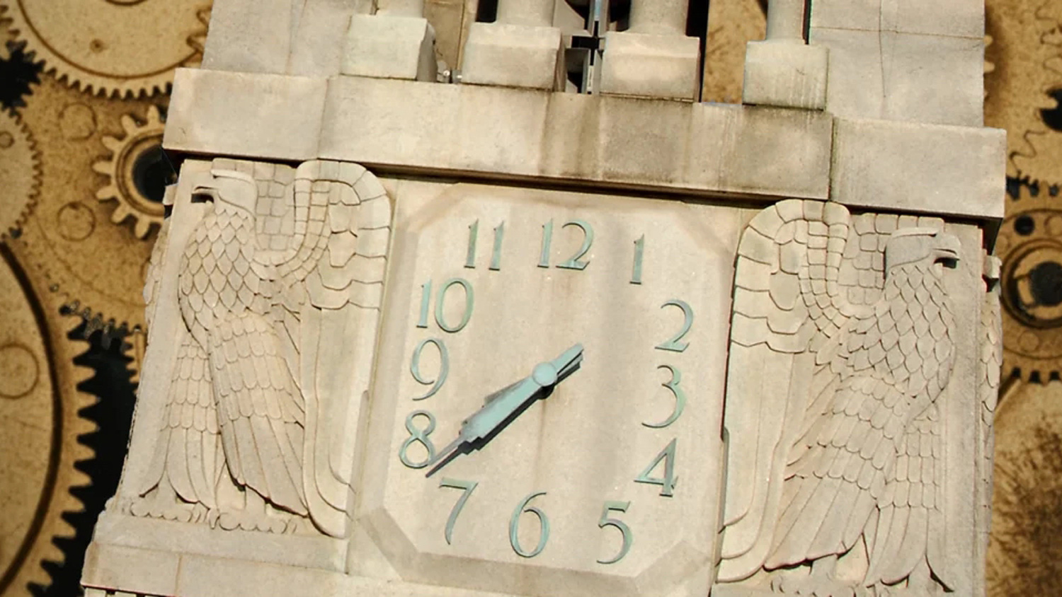 The face of the Memorial Belltower over a background of mechanical gears